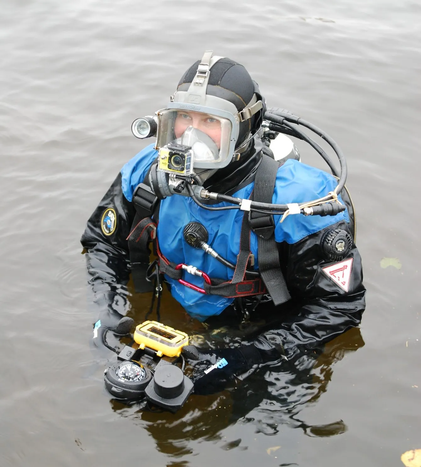 A diver in a full-face mask with an underwater navigator